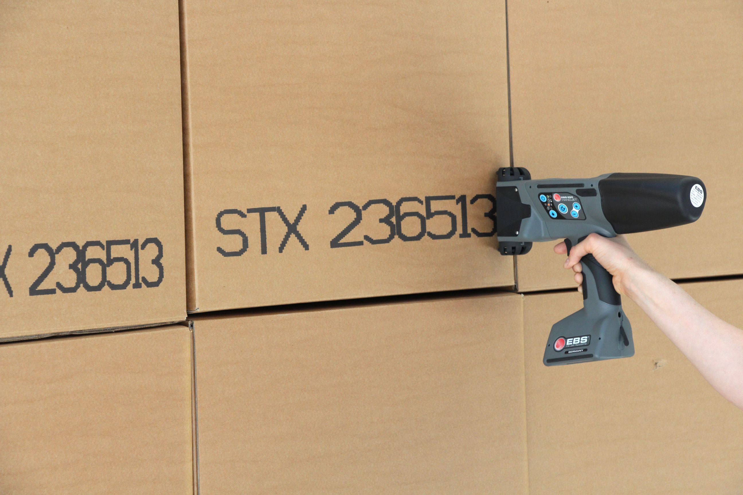 Picture Showing Handheld Inkjet Printer Printing On Cardboard